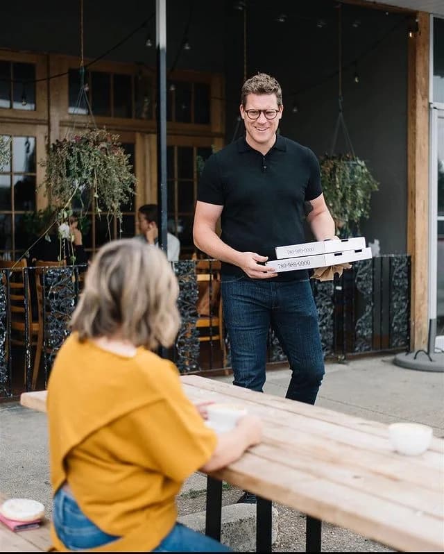 Stone & Wheel pizza boxes handed off on the patio